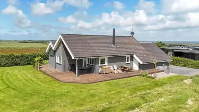 a small house with a deck on a lawn at G506-Lemvig-Myntevej-6-b in Lemvig
