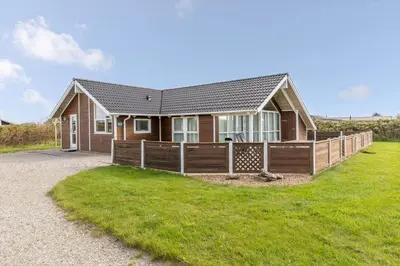 a house with a fence in front of a yard at 247-Harboore-Vejlby-klit-197 in Harboør