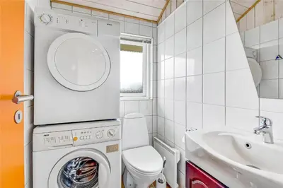 a bathroom with a washing machine and a sink at G131-Lemvig-Skovstjernevej-31 in Lemvig