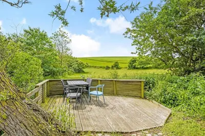 a wooden deck with a table and chairs on it at G107-Lemvig-Sogardevejen-7 in Lemvig