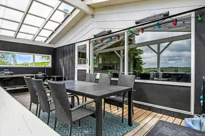a patio with a table and chairs on a deck at G107-Lemvig-Sogardevejen-7 in Lemvig