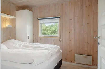 a bedroom with a bed in a wooden wall at 119-Harboore-Neerlandiavej-32 in Harboør