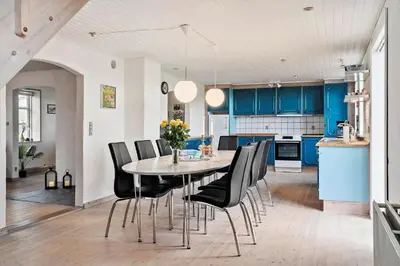 a kitchen with blue cabinets and a table and chairs at 369-Lemvig-Klostervej-39 in Lemvig