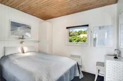 a white bedroom with a bed and a window at 102-Harboore-Vejlby-Klit-21 in Harboør