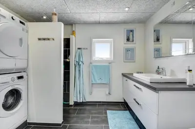 a white bathroom with a sink and a washing machine at 102-Harboore-Vejlby-Klit-21 in Harboør