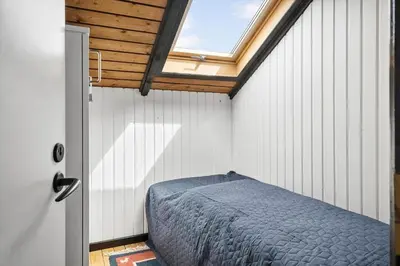 a bedroom with a bed in a room with a window at 209-Harboore-Vejlby-Klit-291-A in Harboør