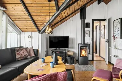 a living room with a couch and a table with a fireplace at 209-Harboore-Vejlby-Klit-291-A in Harboør