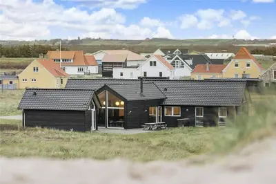a black house in front of a group of houses at 316-Harboore-Crownvej-9 in Harboør