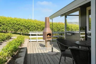 a patio with a wood fired oven on a deck at G120-Lemvig-Gyvelvej-20 in Lemvig