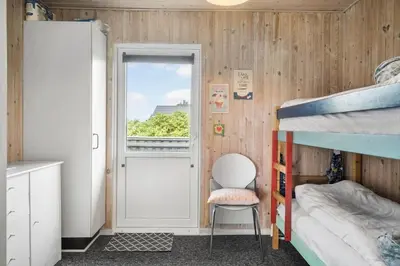 a small bedroom with a bunk bed and a window at 134-Harboore-Karolinevej-8 in Harboør
