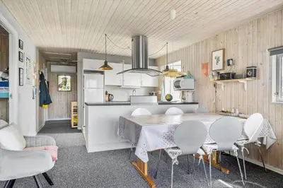 a kitchen and dining room with a table and chairs at 134-Harboore-Karolinevej-8 in Harboør