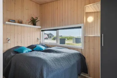a bedroom in a tiny house with a bed and a window at 227-Harboore-Bjergehusvej-4 in Harboør