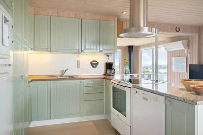 a kitchen with green cabinets and a sink at G180-Lemvig-Bellisvej-80 in Lemvig