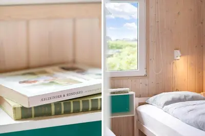 a couple of books sitting on a shelf next to a bed at G180-Lemvig-Bellisvej-80 in Lemvig