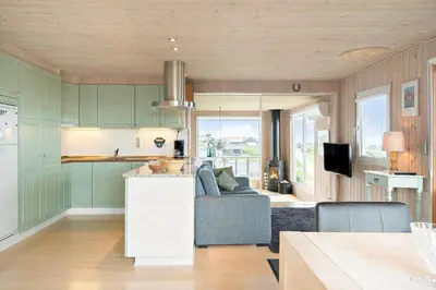 a kitchen and living room with green cabinets and a couch at G180-Lemvig-Bellisvej-80 in Lemvig