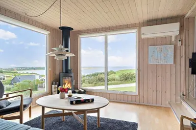 a living room with a table and large windows at G180-Lemvig-Bellisvej-80 in Lemvig