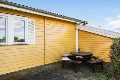 a patio with a table and chairs next to a building at G147-Lemvig-Syrenvej-47 in Lemvig