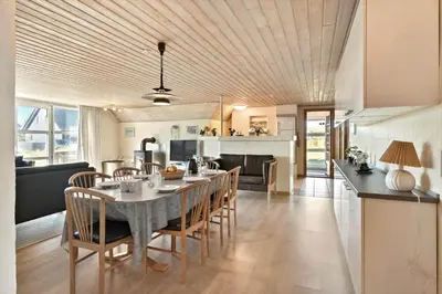 a dining room and kitchen with a table and chairs at 377-Harboore-Fourmivej-56 in Harboør
