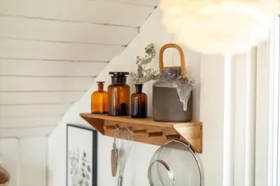 a hallway with wooden shelves with bottles and a mirror at 804-Harboore-Neerlandiavej-214 in Harboør