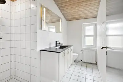 a white bathroom with a sink and a toilet at 803-Harboore-Merchantvej-9-A in Harboør