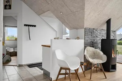 a kitchen with white chairs and a fireplace at 805-Harboore-Vejlby-klit-247 in Harboør