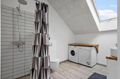 a bathroom with a toilet and a washing machine at 805-Harboore-Vejlby-klit-247 in Harboør