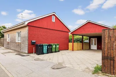a red building with three trash cans in front of it at 727-Thyboron-Magevej-10 in Thyborøn