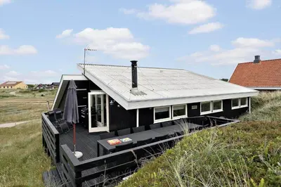 a black house on a trailer in a field at 807-Harboore-Dalevej-9 in Harboør