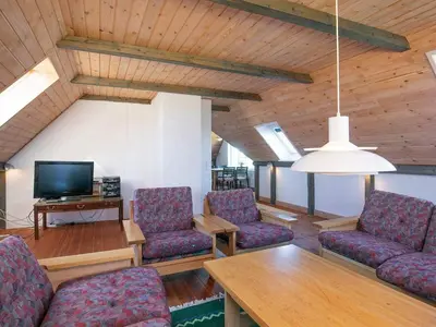 a living room with chairs and a tv and a table at 12 person holiday home in Lemvig in Lemvig