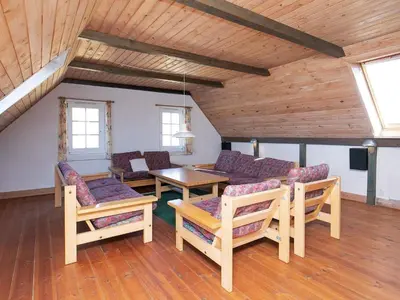 a living room with a couch and a table and chairs at 12 person holiday home in Lemvig in Lemvig