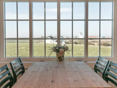 a dining room table with chairs and a vase with a plant at 12 person holiday home in Lemvig in Lemvig