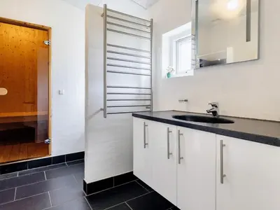 a white kitchen with a sink and a mirror at Tranquil Retreat in Nature s Embrace-By Traum in Brovst