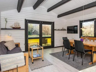 a living room with a table and a couch and a dining room at 4 person holiday home in Nibe-By Traum in Nibe