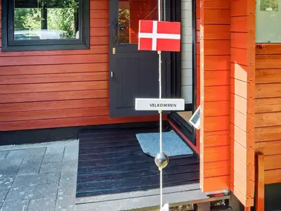 a door to a red house with a sign that reads wait courage at 4 person holiday home in Nibe-By Traum in Nibe