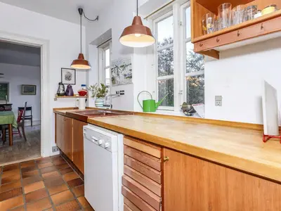 a kitchen with wooden cabinets and a counter top at 5 person holiday home in Løgstør in Løgstør