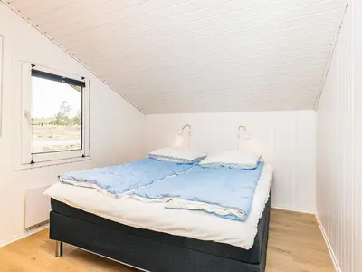 a bed in a white room with a window at 12 person holiday home in Saltum-By Traum in Saltum
