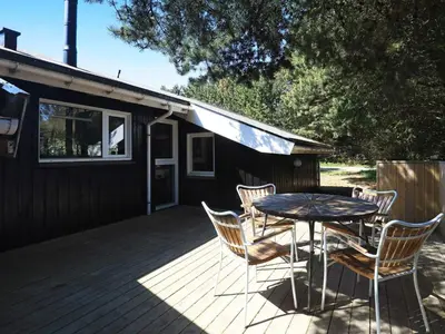 a patio with a table and chairs on a deck at 12 person holiday home in Saltum-By Traum in Saltum