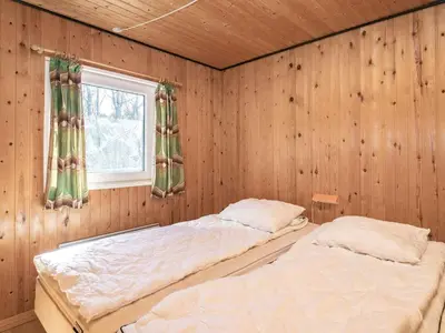 two beds in a room with wooden walls and a window at 6 person holiday home in Hurup Thy-By Traum in Sindrup