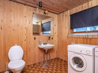 a bathroom with a toilet a sink and a washing machine at 10 person holiday home in Fur in Fur