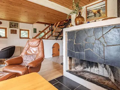 a living room with a stone fireplace and a chair at 10 person holiday home in Fur in Fur