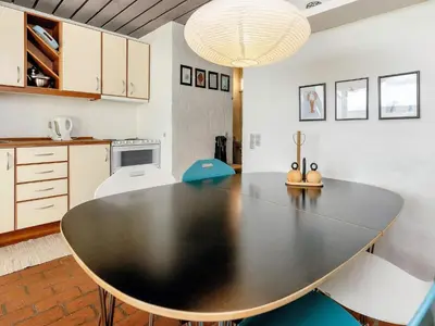 a kitchen with a table and chairs in a room at Seaside Serenity in TAYsinge-By Traum in Brovst