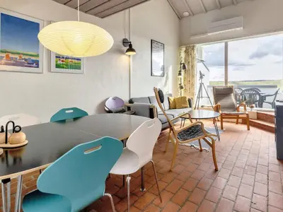 a living room with a table and chairs at Seaside Serenity in TAYsinge-By Traum in Brovst