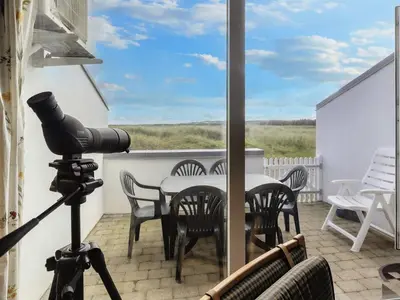 a camera on a balcony with a table and chairs at Seaside Serenity in TAYsinge-By Traum in Brovst