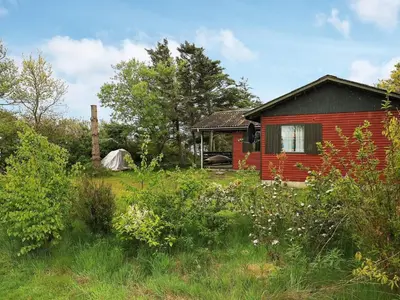 a red house with a tent in a field at 6 person holiday home in Vinderup in Vinderup
