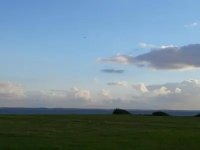 a field with green grass and a cloudy sky at 6 person holiday home in Vinderup in Vinderup