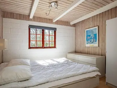 a bedroom with a large bed with a window at 6 person holiday home in Thyholm in Thyholm