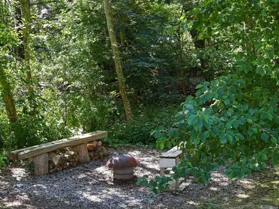 a park with a bench and a turtle in the woods at 6 person holiday home in Thyholm in Thyholm