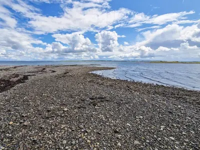 a beach with rocks and water on a cloudy day at 6 person holiday home in Thyholm in Thyholm