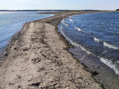 a rocky shoreline with waves in the water at 6 person holiday home in Thyholm in Thyholm