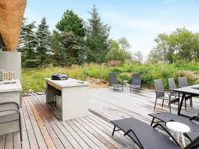a wooden deck with tables and chairs and a stove at 7 person holiday home in Fjerritslev-By Traum in Fjerritslev